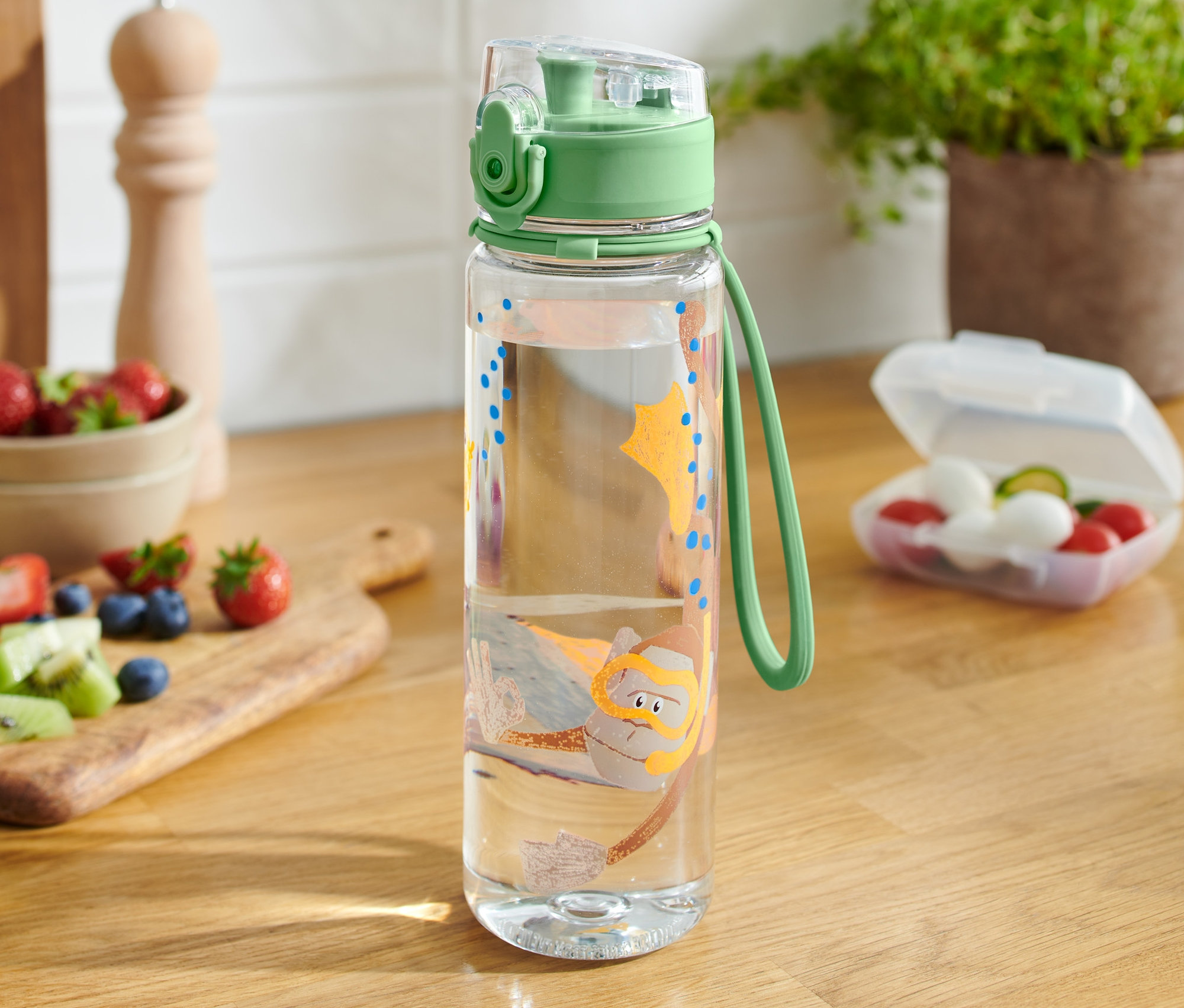 Une gourde transparente avec un motif de plongeur sur une table en bois.