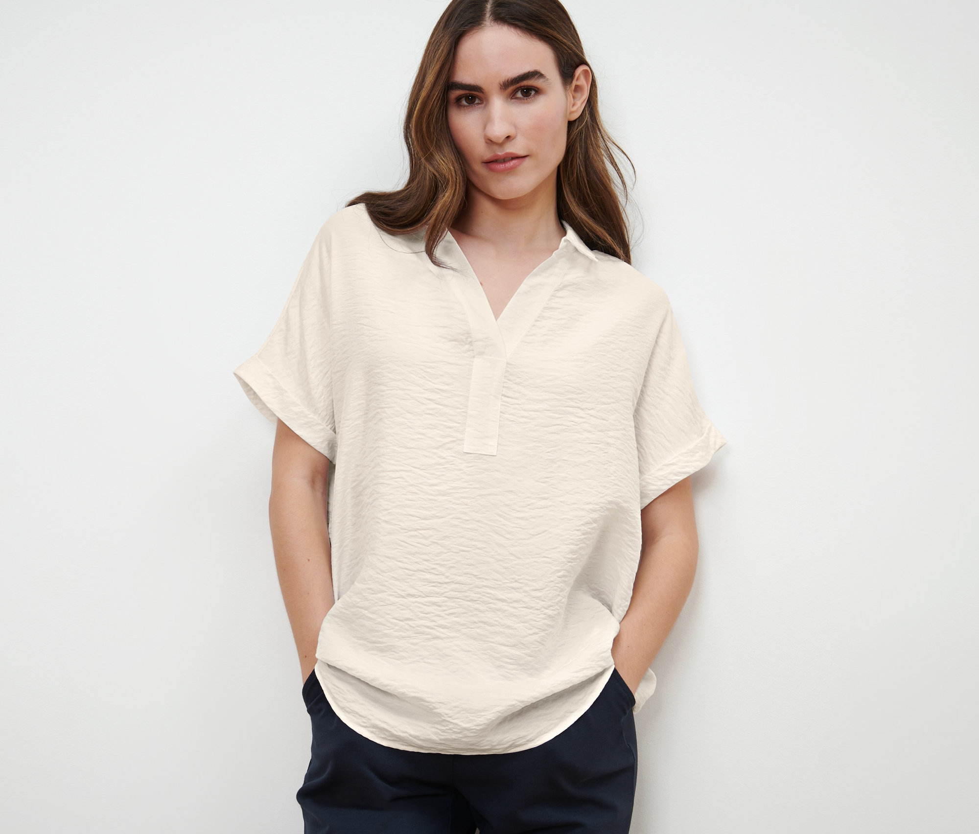 Femme posant dans une blouse à manches courtes.