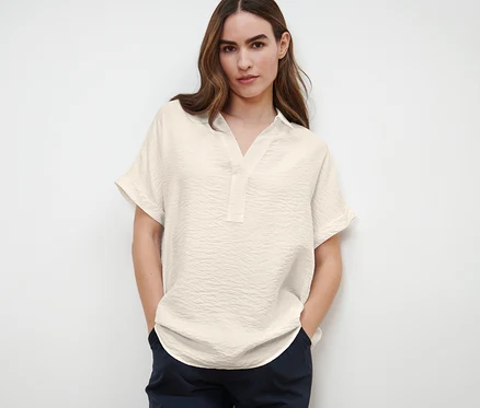 Femme posant dans une blouse à manches courtes.