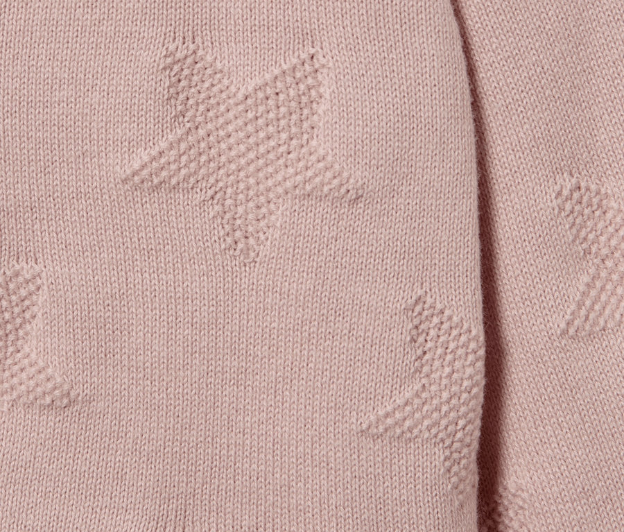 Détail d'une jaquette en maille pour enfant avec des étoiles.