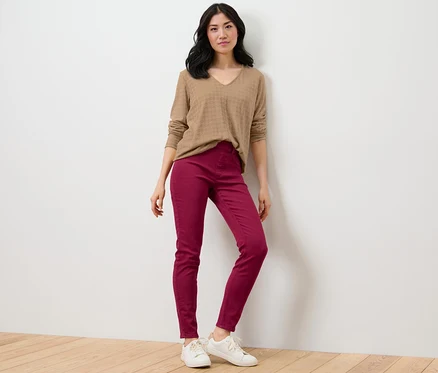 Une femme pose en pull marron et tregging – Fit « Nelly ».