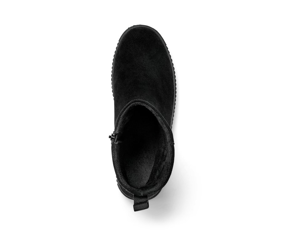 Une bottine noire en cuir velours sur un fond blanc.