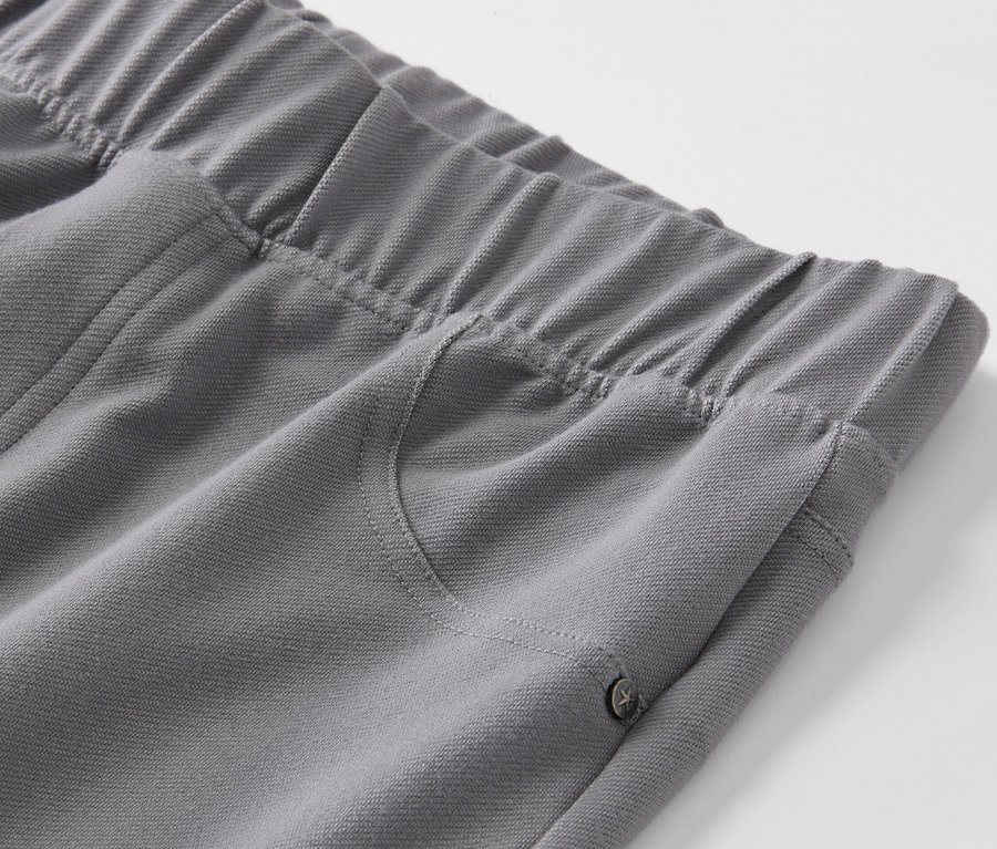 Gros plan sur un legging gris à l'aspect jean avec une taille élastique et une poche.