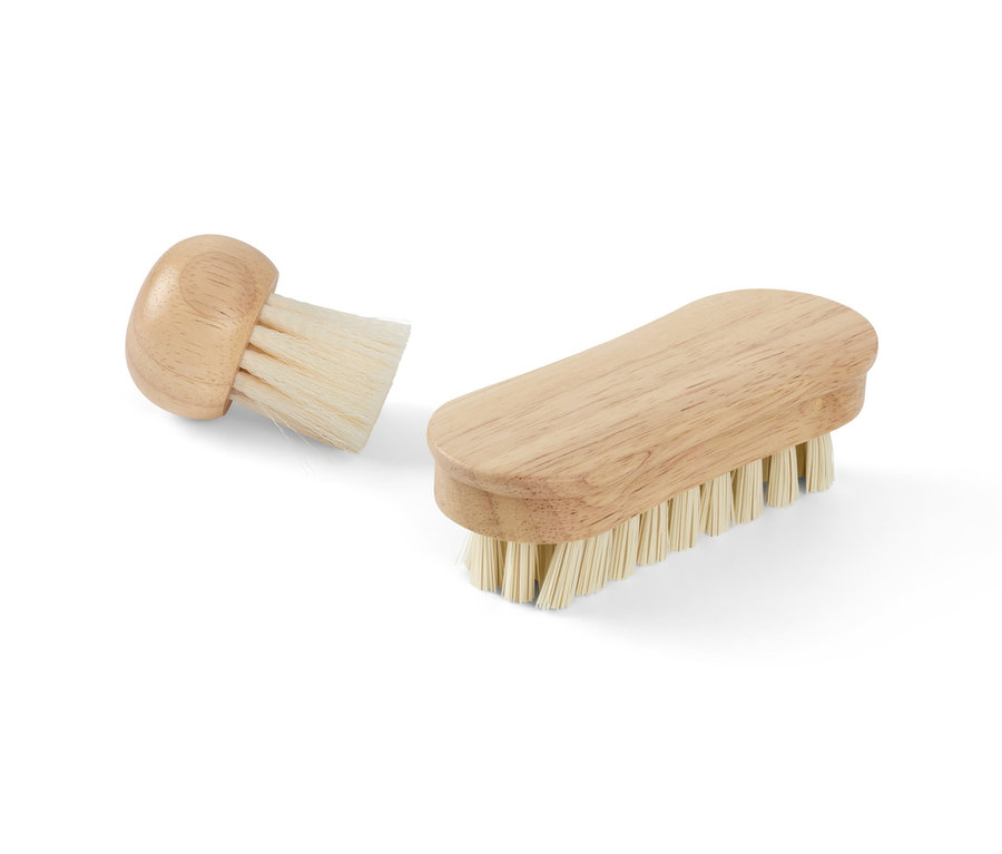 Deux brosses à légumes avec manche en bois posées sur un fond blanc.