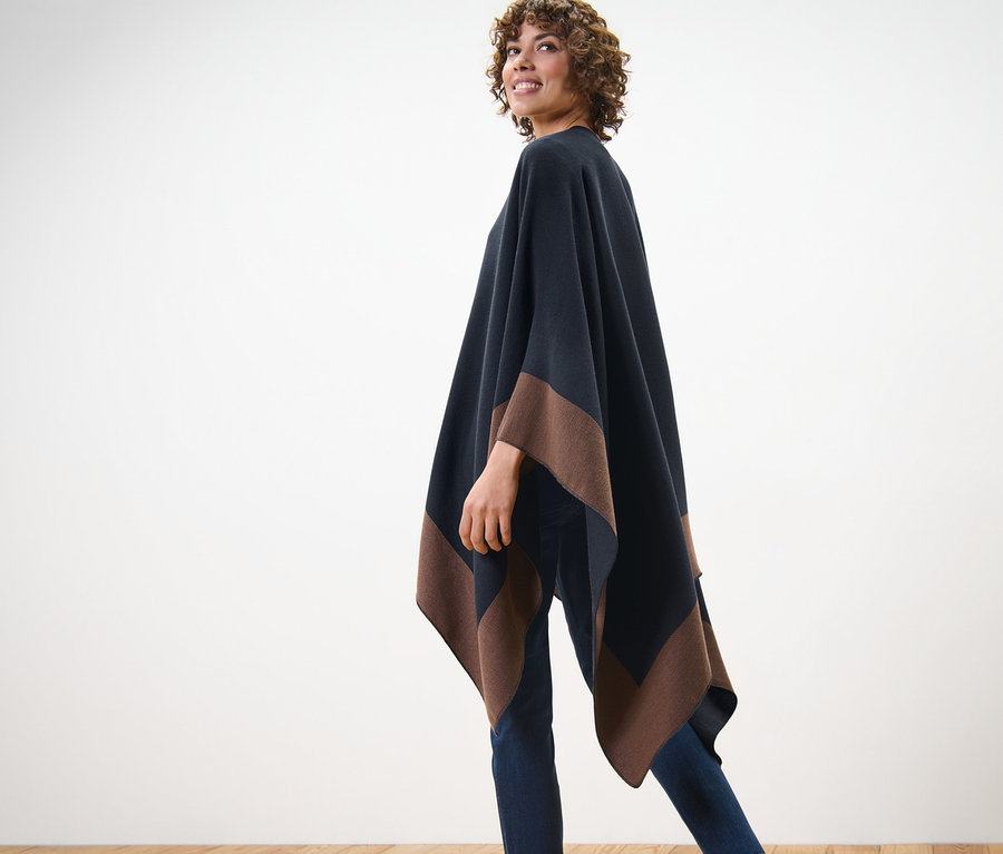 Femme posant dans un poncho tendance.