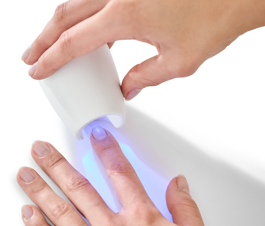 Femme utilisant une lampe UV du kit manucure-pédicure 5 en 1.