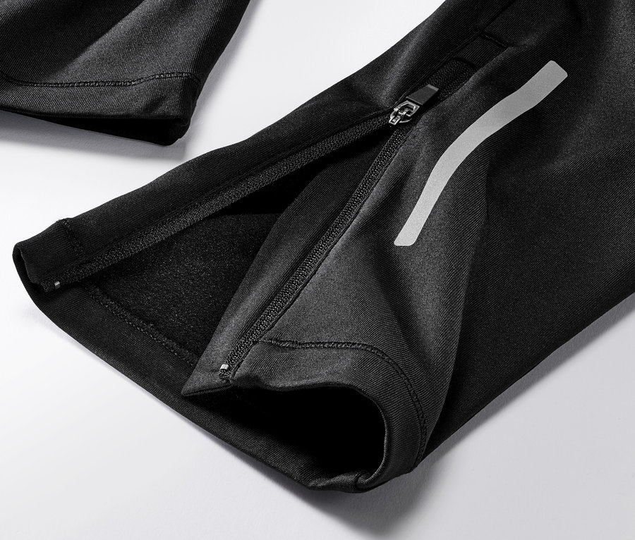 Gros plan sur un legging de course coupe-vent noir avec fermeture éclair.