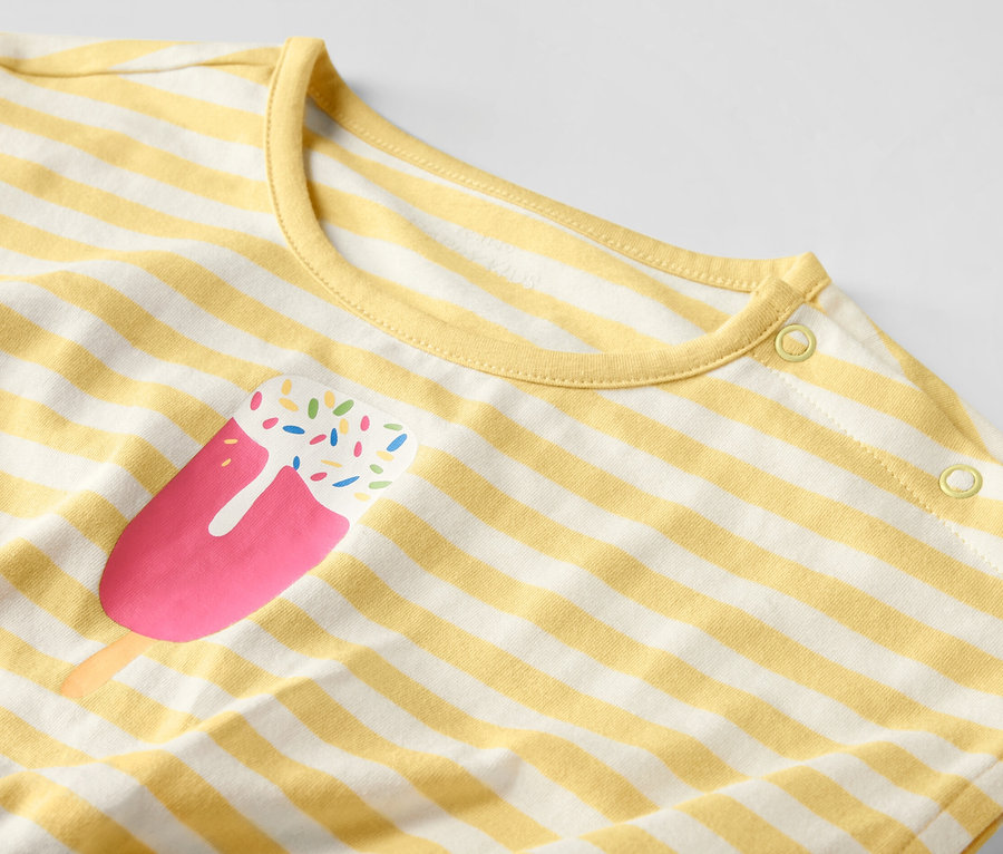 Gros plan sur une combinaison pour enfant rayée jaune et blanc avec un motif de glace.