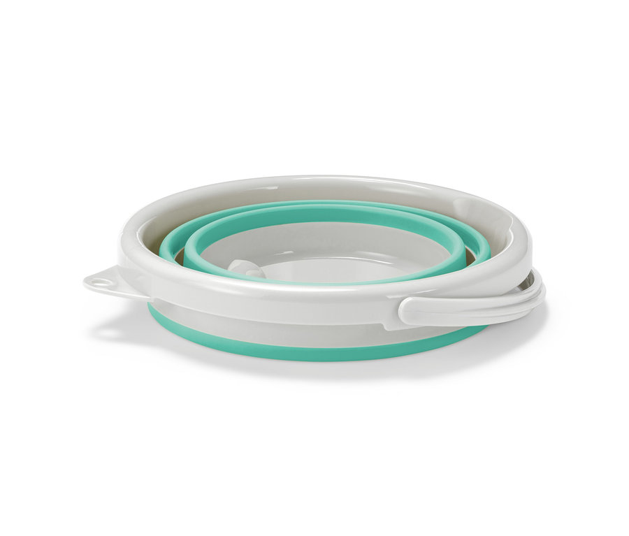 Un seau pliable blanc et turquoise est plié.