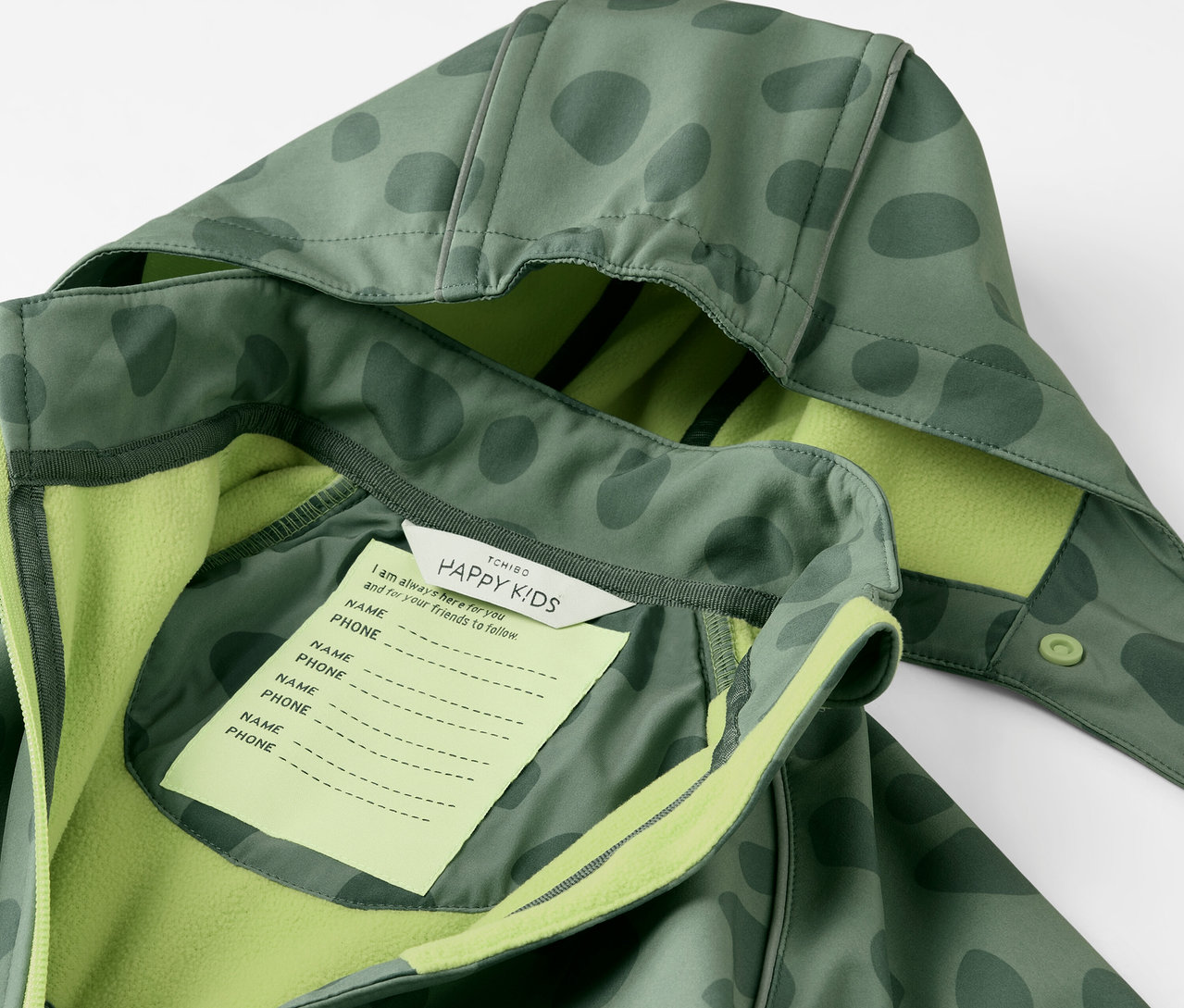 Détail d'une combinaison en softshell pour enfant avec capuche et étiquette pour le nom.