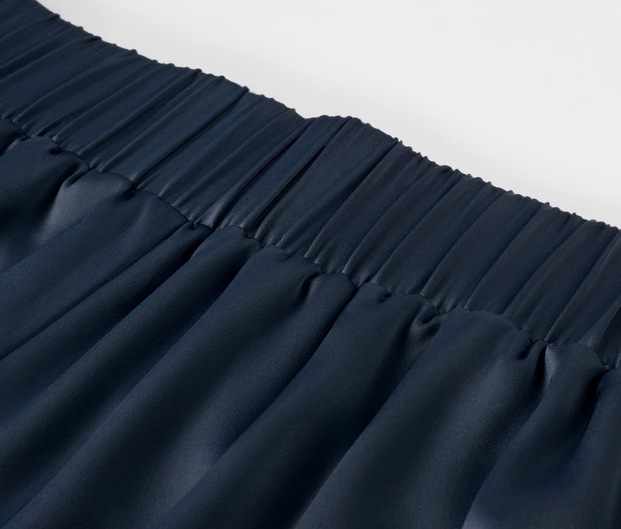 Détail d'un pantalon en satin, bleu marine.
