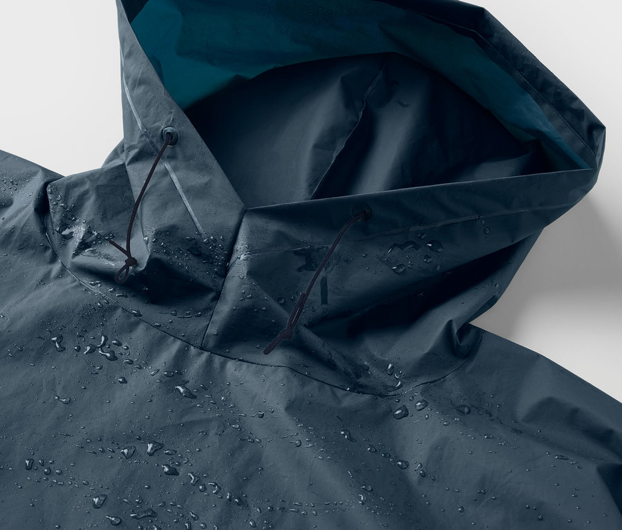 Gros plan sur la capuche d'un poncho de pluie bleu avec des gouttes d'eau.