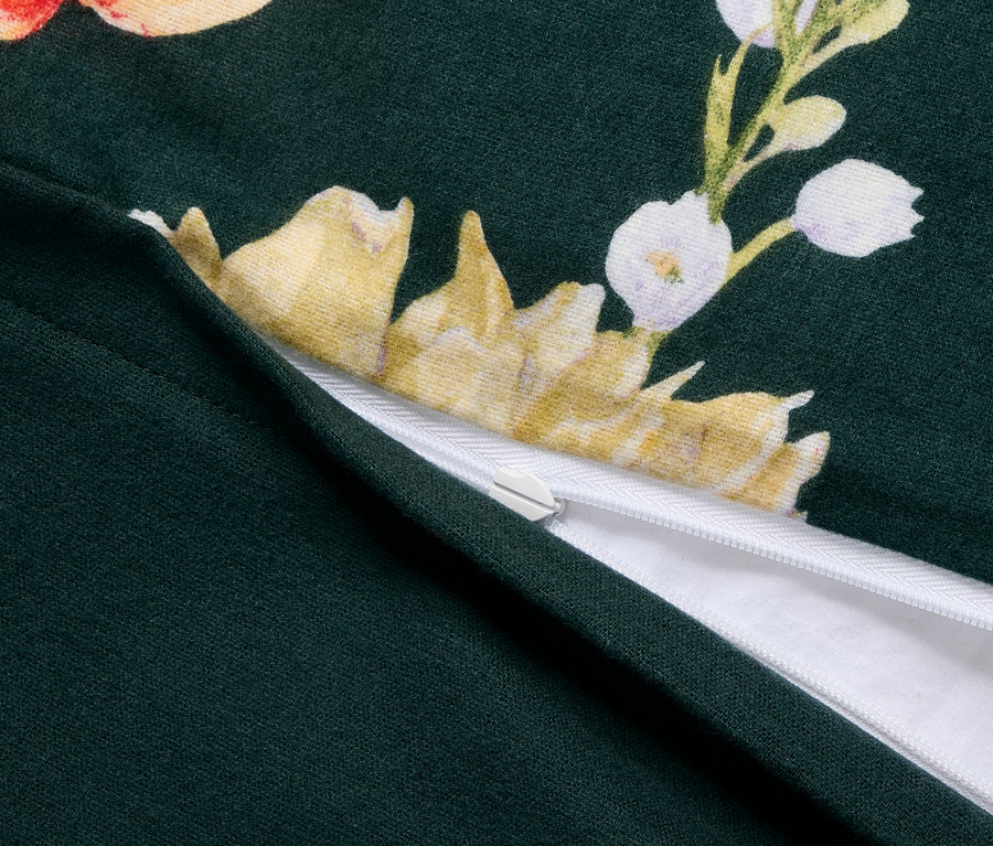 Gros plan sur une parure de lit en molleton verte de taille standard avec un motif floral et une fermeture éclair.