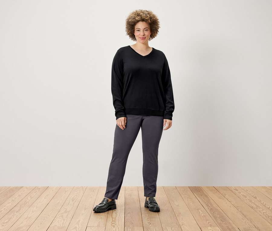 Femme posant en pull et pantalon stretch.