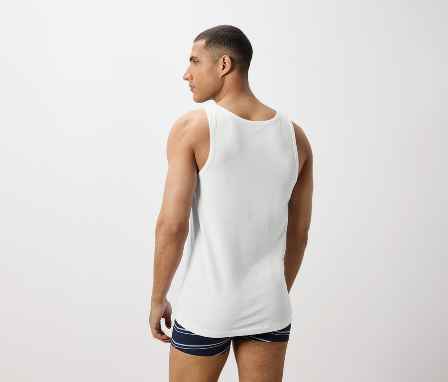 Homme vu de dos portant un débardeur blanc et un boxer rayé.