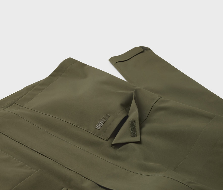 Gros plan sur une veste vert olive avec une poche de poitrine et une manche.