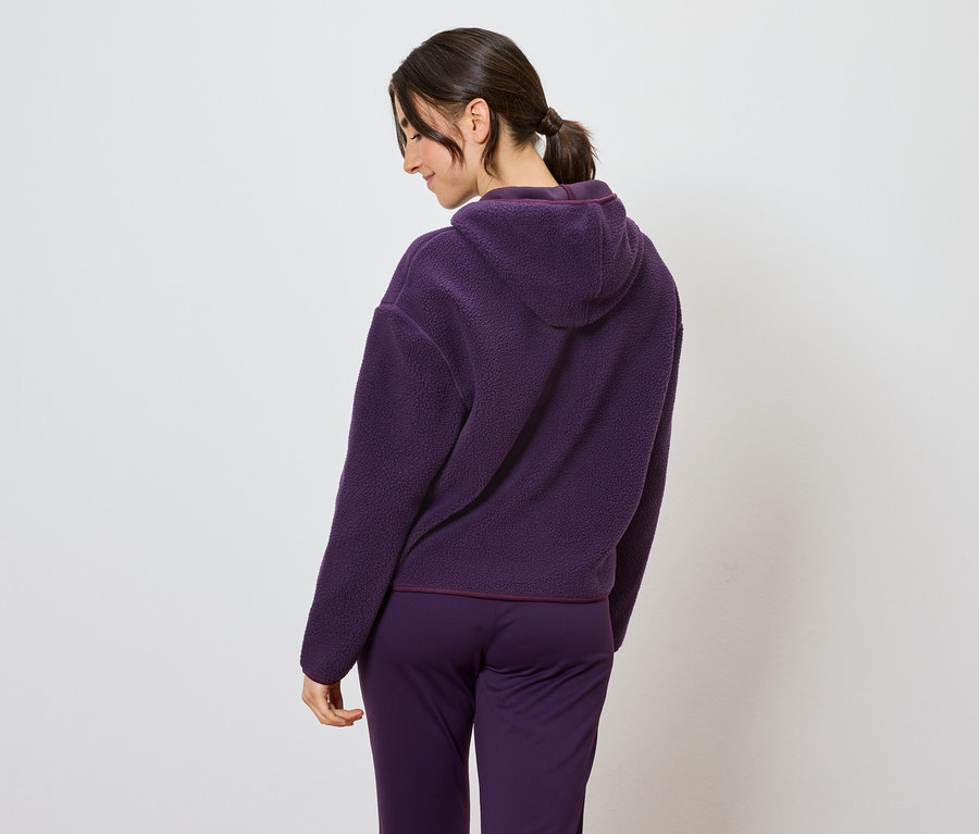 Femme portant un survêtement violet à capuche, vue de dos.