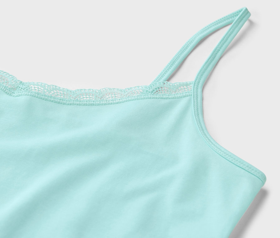 Gros plan sur un 2 maillots de corps bleu clair avec de la dentelle sur l'ourlet.