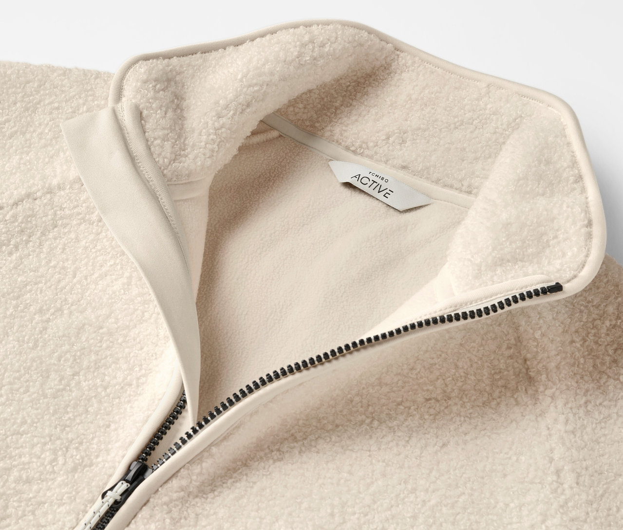 Gros plan d'une veste polaire beige avec fermeture éclair et col.