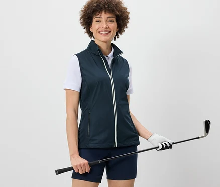 Femme portant une veste en softshell et tenant un club de golf.