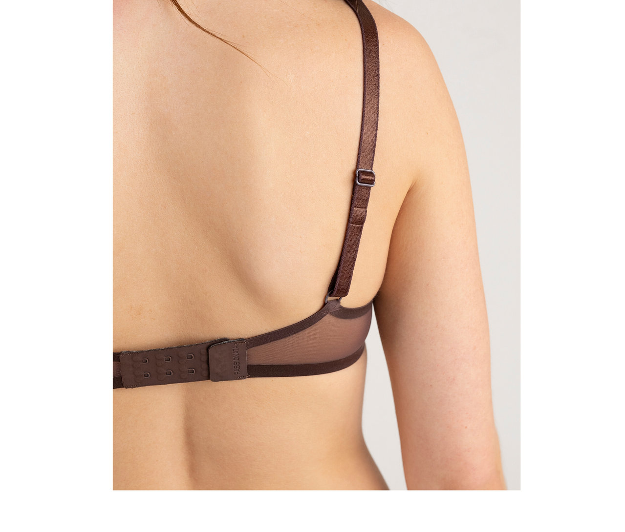 Vue de dos d'une personne portant un soutien-gorge Passionata « Bianca » couleur chocolat noir, montrant la bretelle réglable et la fermeture à agrafes.