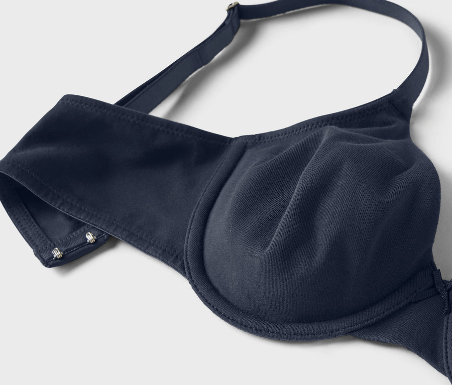 Gros plan d'un soutien-gorge à armatures bleu marine avec bretelles réglables sur fond blanc.