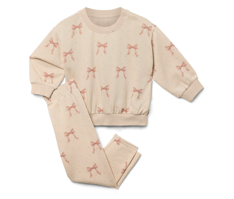 Un ensemble beige à motif de noeuds, composé d'un sweat-shirt et d'un pantalon.