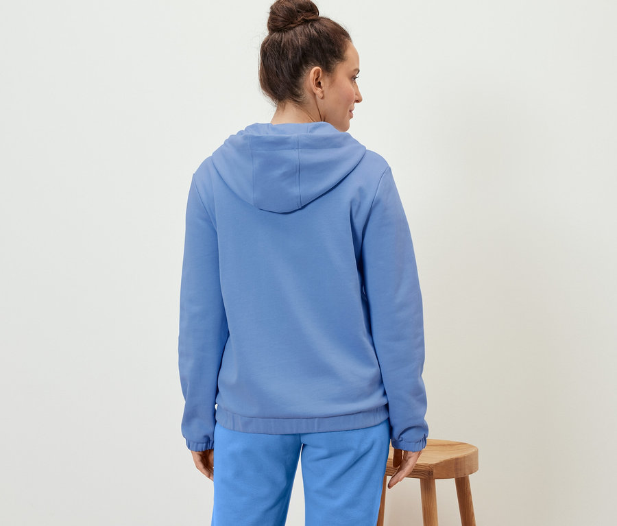 Femme portant un sweat à capuche bleu clair.