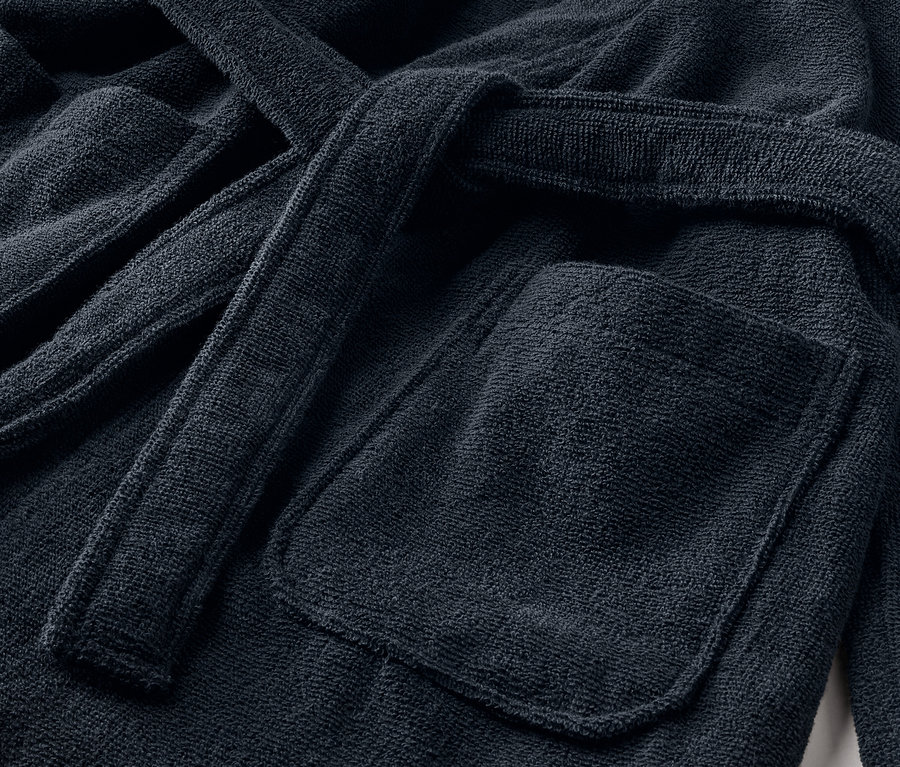 Vue détaillée d'un peignoir pour enfant avec une poche et une ceinture.