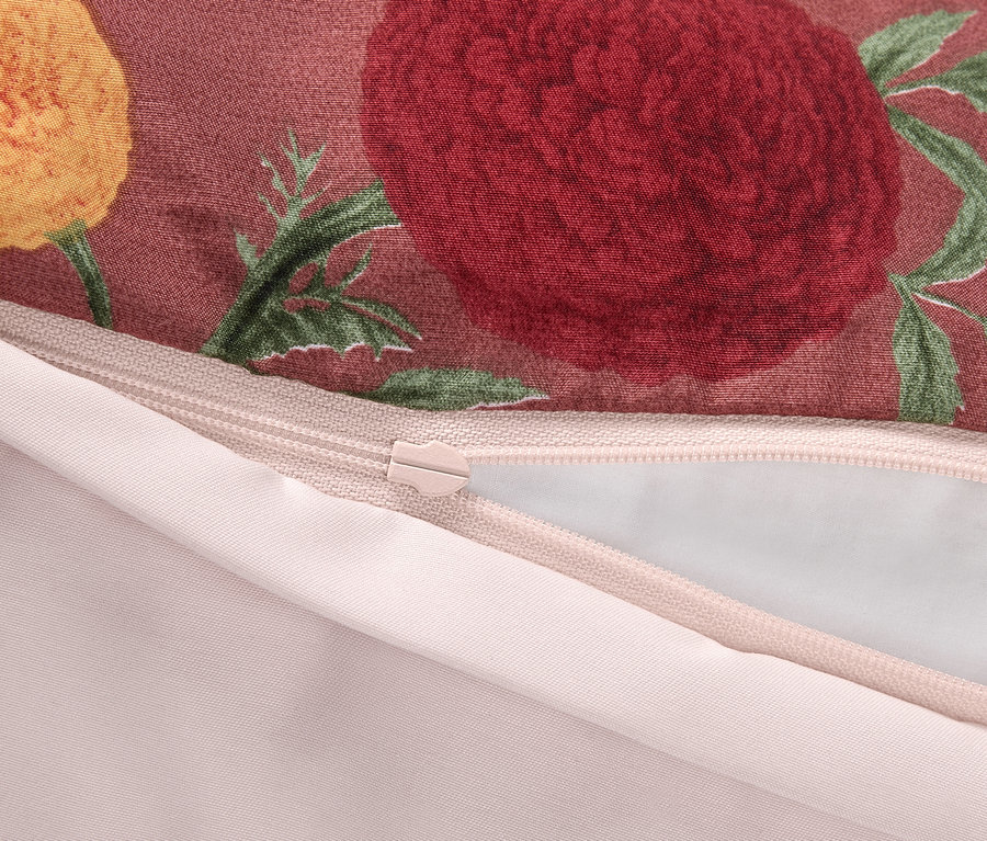 Détail de la fermeture éclair sur une taie d'oreiller à motif floral.