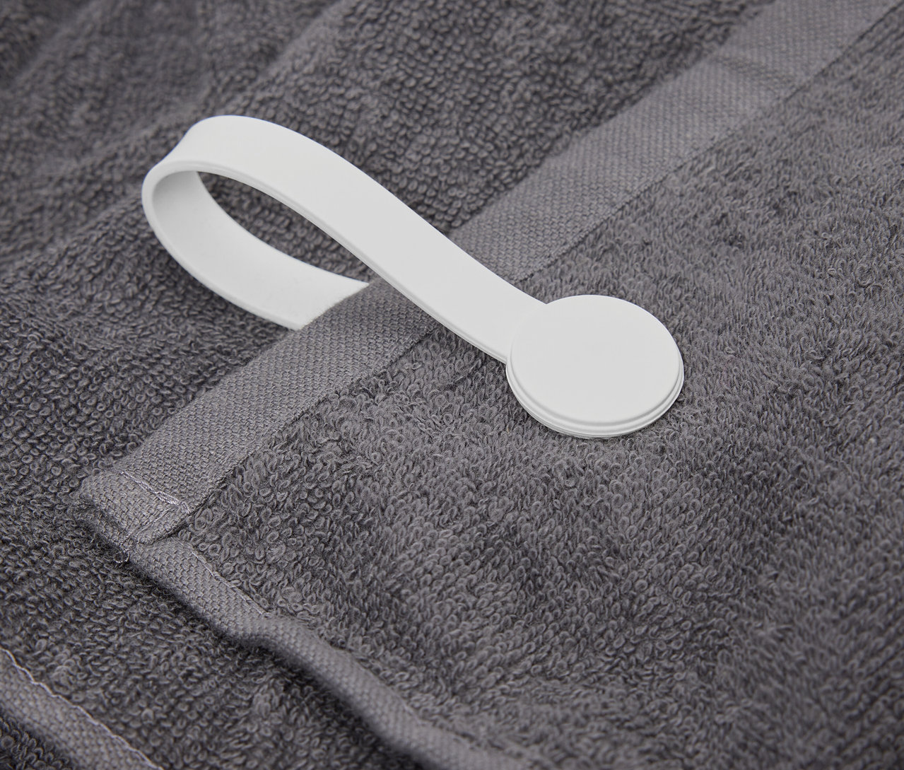 Gros plan d'une serviette grise avec une boucle blanche.