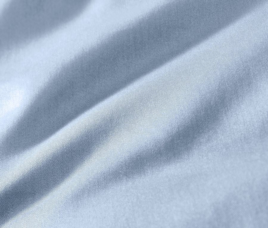 Gros plan d'une parure de lit en satin de coton bleu clair, grande taille.