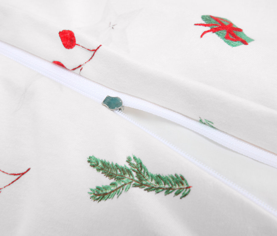 Détail de linge de lit blanc avec fermeture éclair et motifs de Noël.
