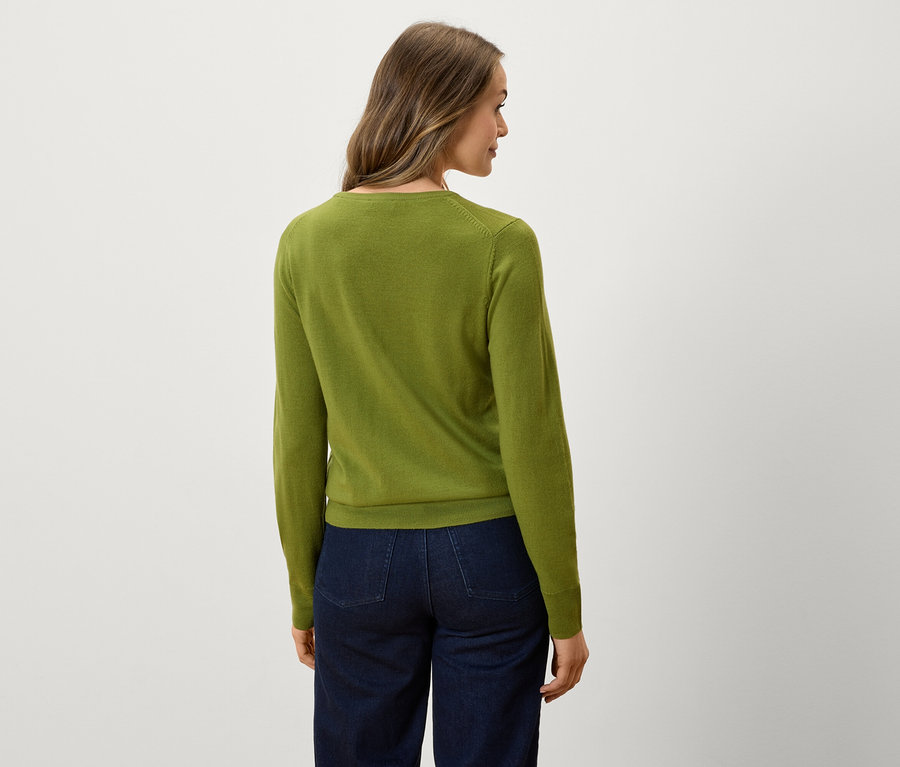 Vue arrière d'une femme portant un pull vert et un jean bleu foncé.