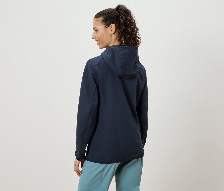 Femme vue de dos, portant une veste à capuche bleu foncé et un pantalon bleu clair.