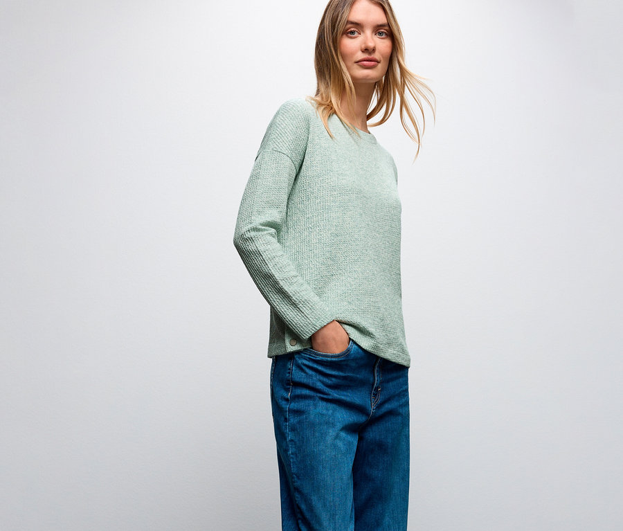 Femme portant un maillot avec structure Street One vert clair et un jean bleu.
