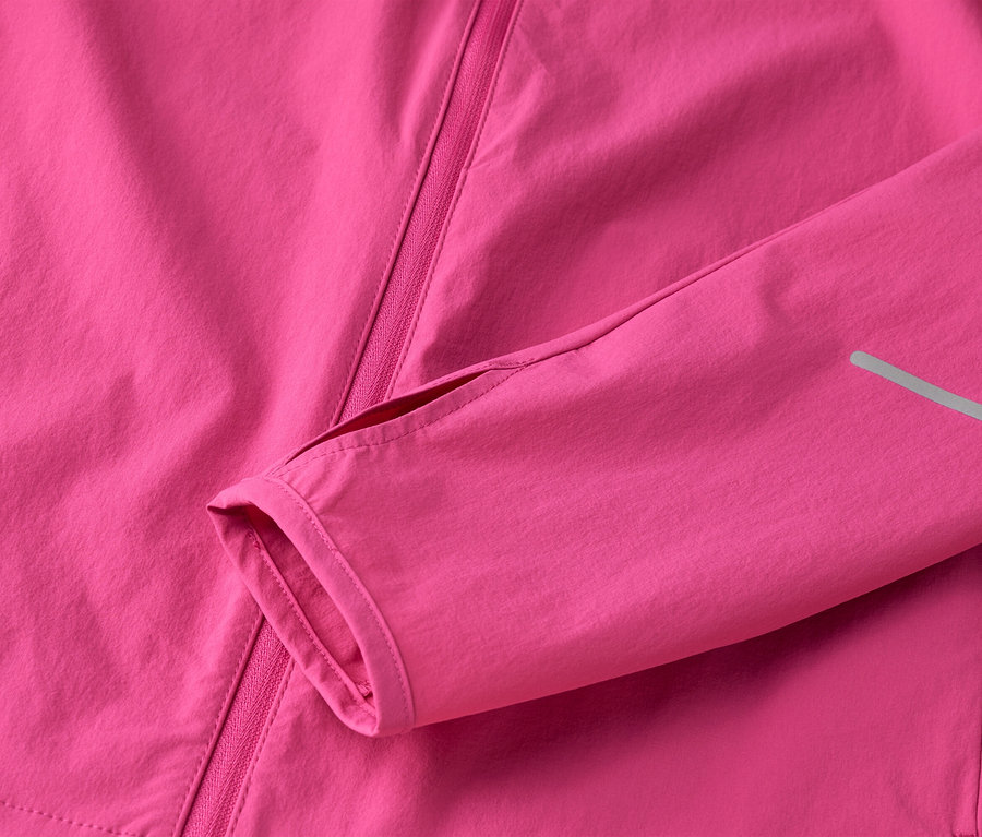 Gros plan d'une veste rose avec fermeture éclair et manche avec trou pour le pouce.