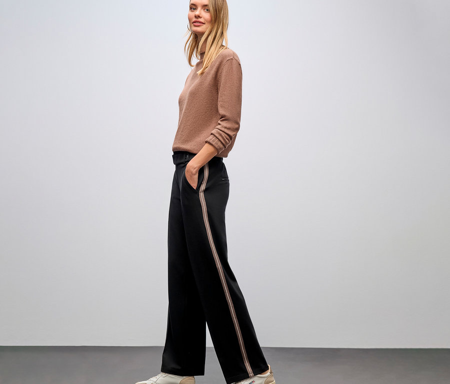 Femme posant de profil en pull marron et pantalon noir Straight Leg avec galon Street One.