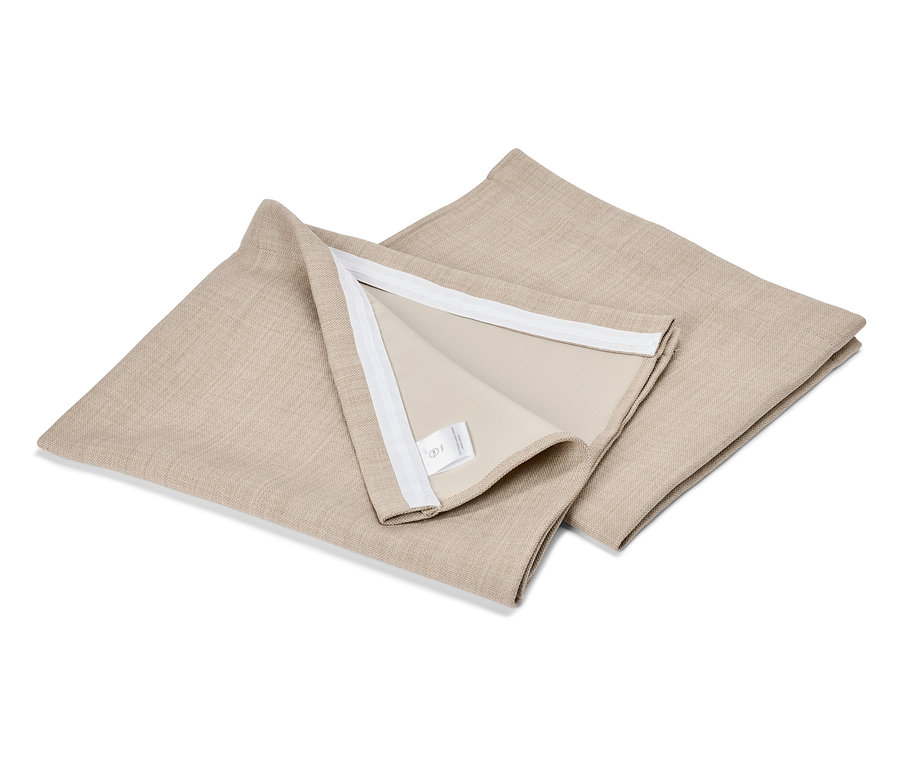 Deux housses de coussin carrées beiges sont posées l'une sur l'autre sur une surface blanche.