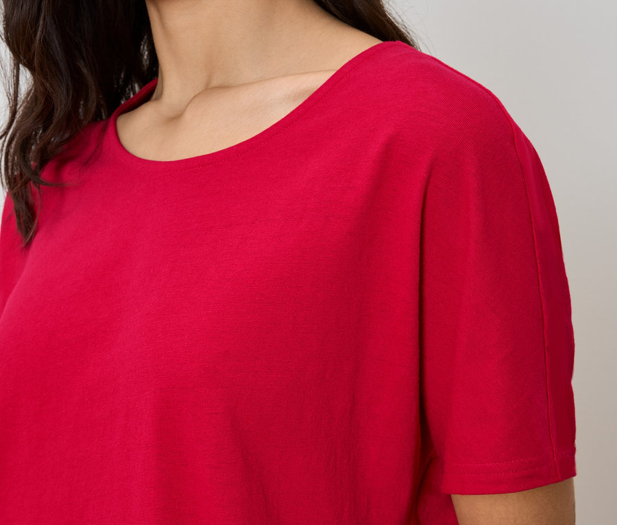 Gros plan d'une femme portant un t-shirt rouge.