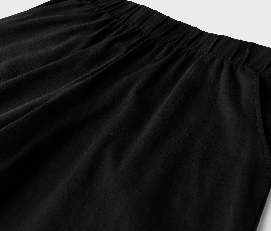 Gros plan d'un pantalon noir avec élastique à la taille et poche latérale.
