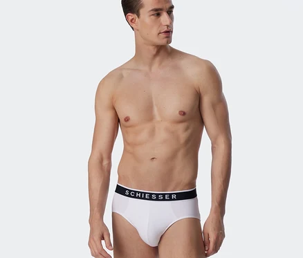 Homme torse nu portant un slip Rio SCHIESSER blanc.