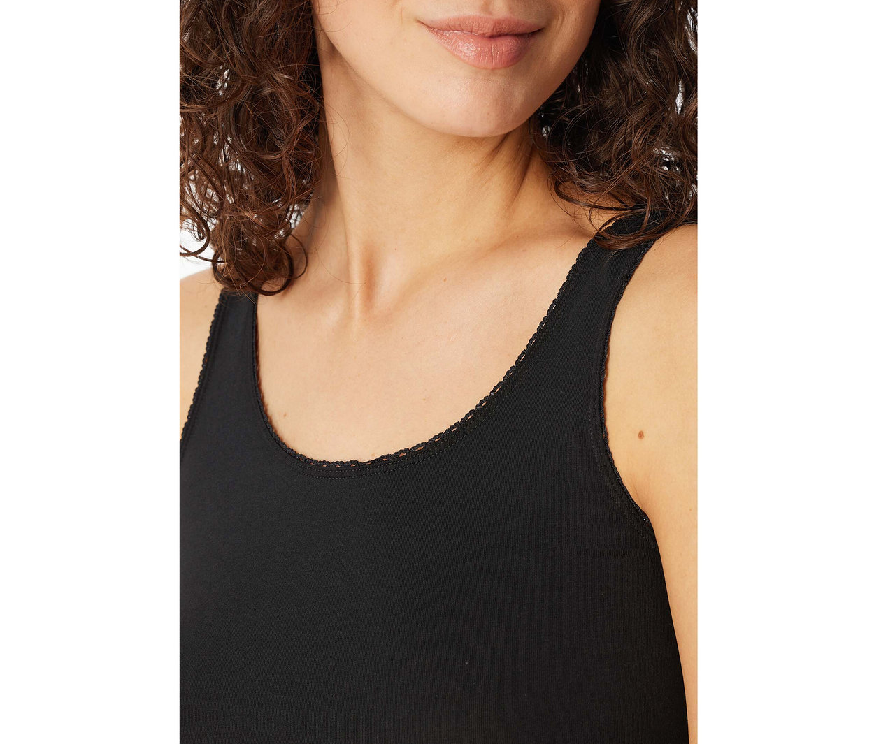 Femme portant un top à bretelles SCHIESSER noir avec une bordure en dentelle au décolleté.