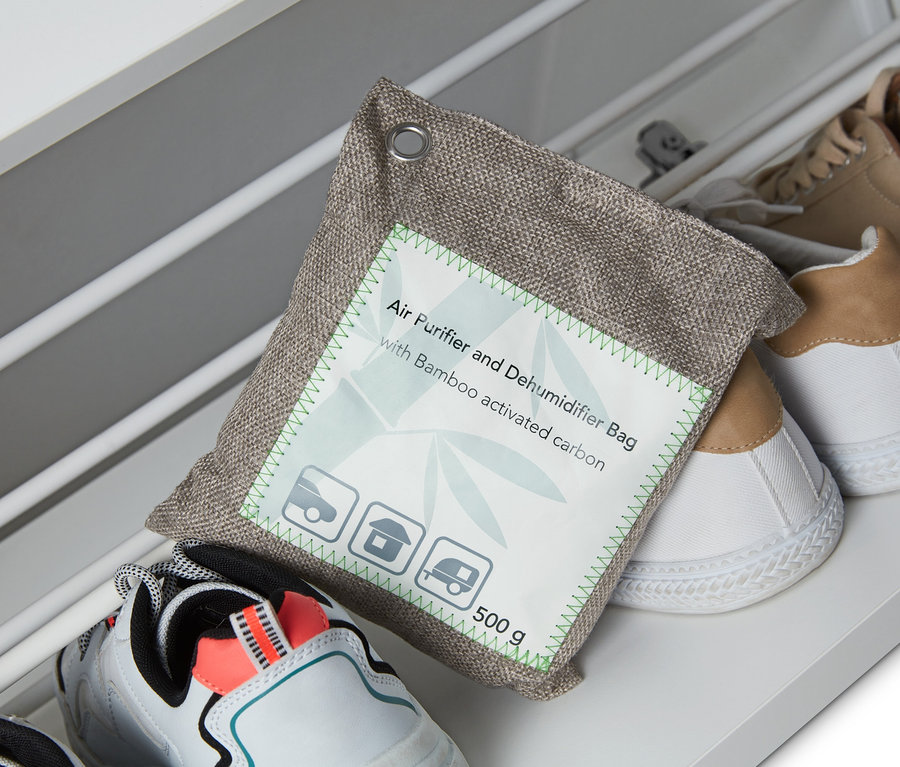 Un coussin purificateur d’air et absorbeur d’humidité repose sur des chaussures dans une étagère à chaussures.