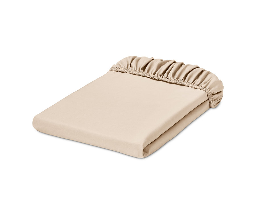 Drap-housse en jersey beige plié sur un fond blanc.
