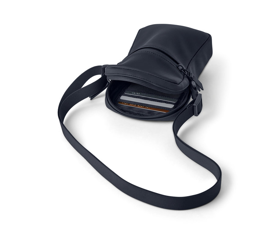 Un sac à bandoulière de pluie bleu marine avec une bandoulière et une fermeture éclair, avec des cartes visibles à l'intérieur.
