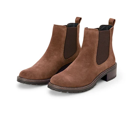 Deux bottines en cuir velours marron sur fond blanc.