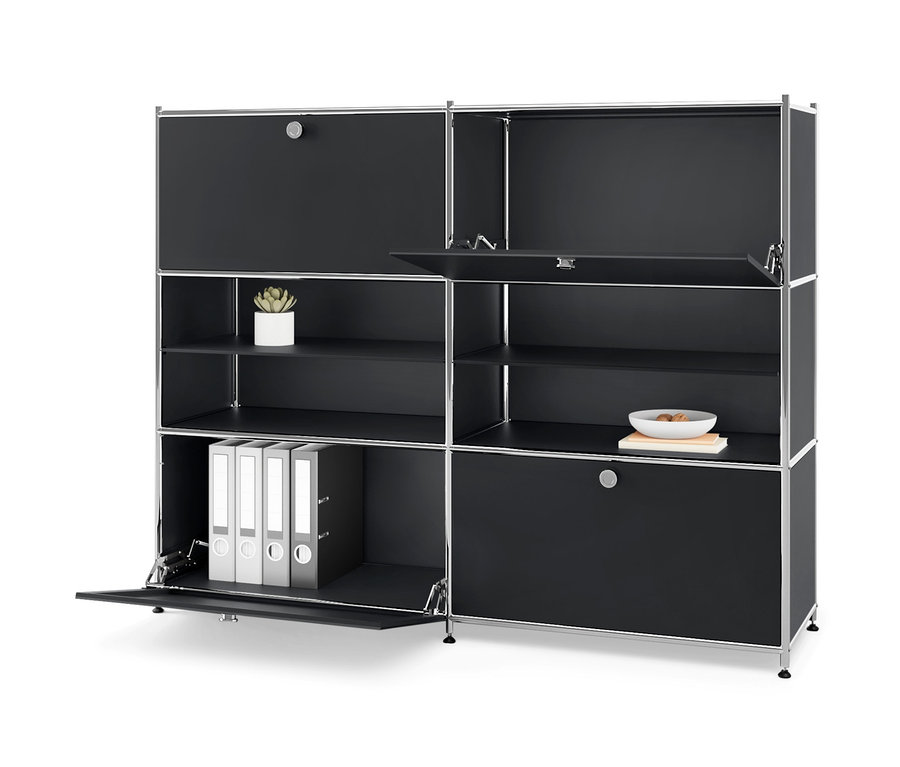 Commode en métal noire « CN3 » avec quatre compartiments à rabat, dont certains sont ouverts et révèlent des classeurs, une plante et un bol.