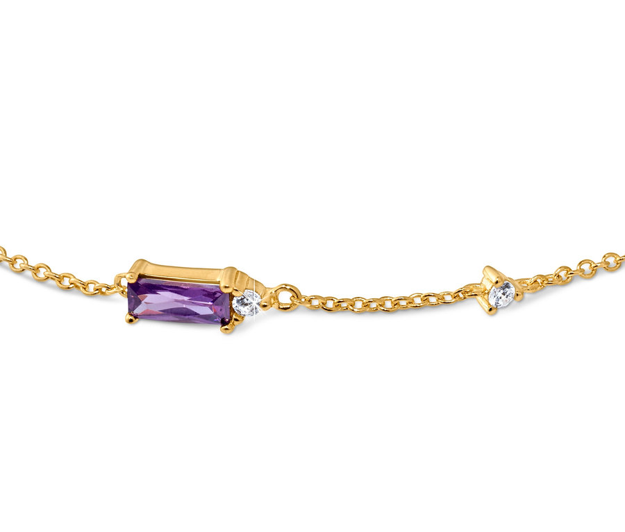Détail d'un bracelet doré avec une pierre violette et des cristaux transparents.