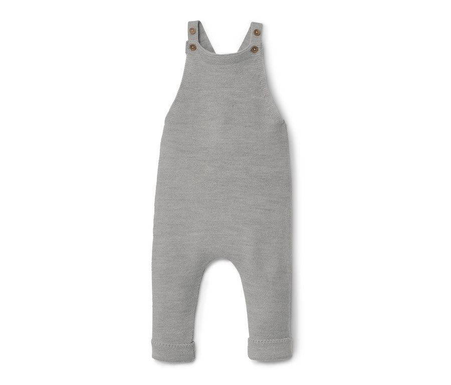 Une salopette en laine mérinos grise pour bébé est posée sur un fond blanc.